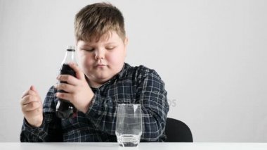 Genç şişman çocuk dökülen soda bir cam içine 50 fps