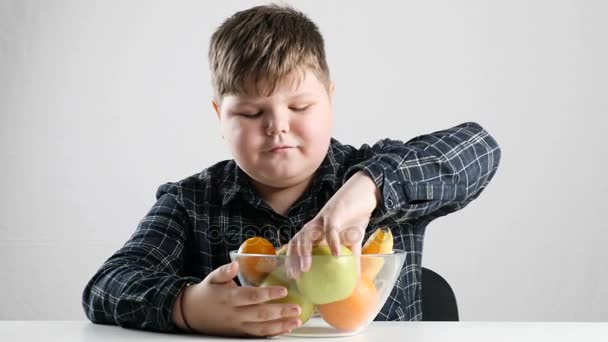 Молодой жирный мальчик кусает зеленое яблоко 50 кадров в секунду — стоковое видео