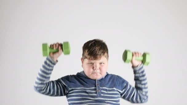 Young fat boy does the exercise with dumbbells pumps the shoulders 50 fps — Stock Video