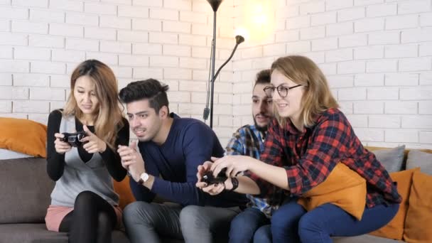 Empresa multinacional sentarse en el sofá, niñas jugando juego de consola 50 fps — Vídeos de Stock