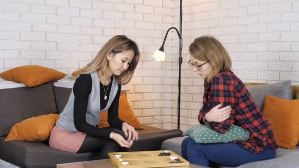 Asian and Caucasian girls playing backgammon 50 fps — Stock Video