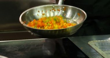 Profesyonel şef fry bir tavada sebze.
