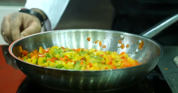 O cozinheiro frite os legumes em uma frigideira . — Vídeo de Stock