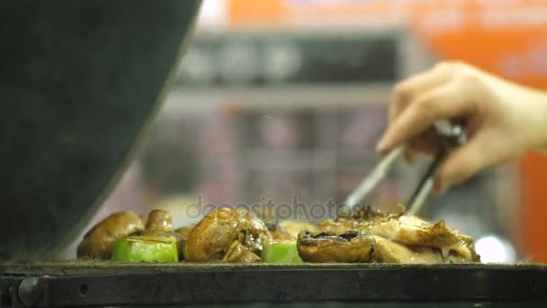 Las manos de los hombres dan vuelta las setas en la parrilla — Vídeos de Stock