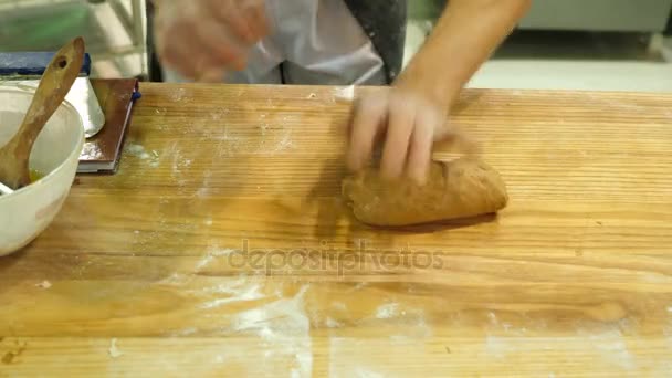 Manos masculinas amasando masa en harina sobre la mesa y llevársela — Vídeos de Stock