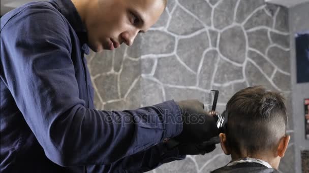 Friseur in schwarzen Handschuhen rasiert Kindern vorsichtig den Nacken, medium shot 60 fps — Stockvideo
