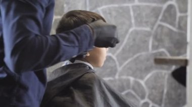 Kuaför siyah eldiven dikkatle tıraş bir Kuaför Asyalı bir çocuk ense 60 fps alışveriş