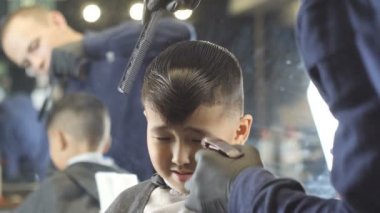 Berber siyah eldiven püskürtme ve Asyalı bir çocuk saç ön tarama 60 fps görüntülemek