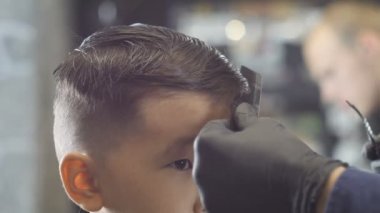 Kuaför siyah eldiven ayarlar bir saç tokası Asyalı bir çocuk saç üzerinde 60 fps