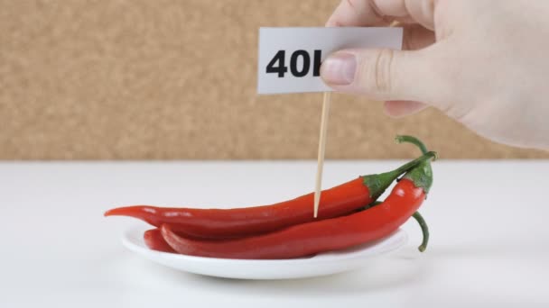 Quantidade de calorias em pimentão, mão masculina coloca um prato com o número de calorias em uma pimenta — Vídeo de Stock