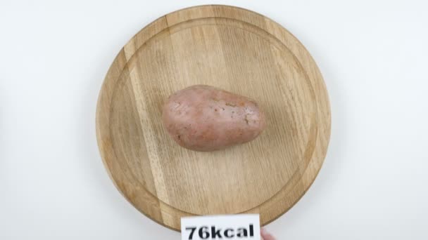 Cantidad de calorías en la patata, mano masculina pone un plato con el número de calorías en una patata, tiro superior — Vídeos de Stock