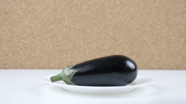 Hoeveelheid calorieën in aubergine, mannelijke hand zet een bord met het aantal calorieën op een aubergine — Stockvideo