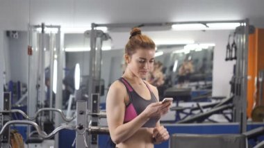 Selfie gülümseyen ve kameraya bakarak egzersizler arasında spor yaparken sportif genç kız 50 fps
