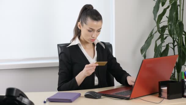 Young attractive girl enters data from credit card into laptop for online purchase 60 fps — Stock Video