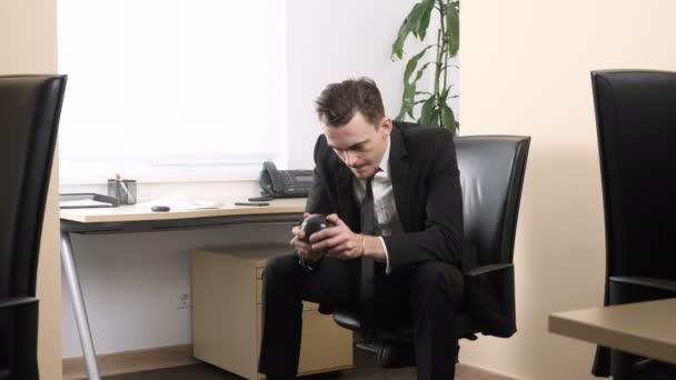 Young man sitting in office shaking Magic Eight Ball and receives a positive response 60 fps — Stock Video