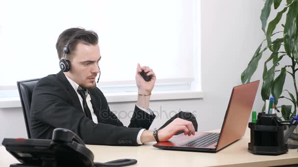 Chico joven en traje de trabajo en el ordenador portátil y aprieta la mano expansor 60 fps — Vídeos de Stock