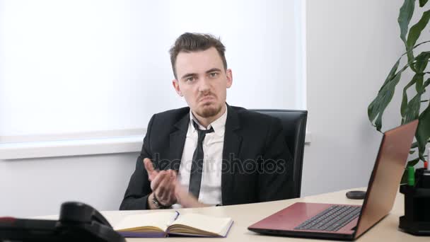 Joven hombre de negocios en traje sentado en la oficina y aplaudiendo, sarcasmo, desprecio 60 fps — Vídeo de stock