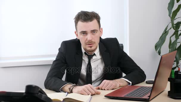 Joven hombre de negocios en traje sentado en la oficina y haciendo facepalm 60 fps — Vídeo de stock