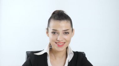 Genç, güzel bir kız gülümseyerek ve kameraya bakıyor. Beyaz arka plan 60 fps