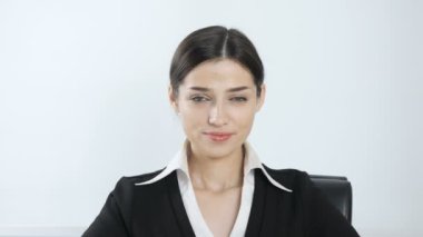 Genç, güzel bir kız gülümseyerek ve kameraya bakıyor. Beyaz arka plan 60 fps