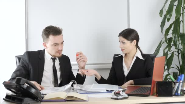Un joven y una mujer de traje discuten un contrato en la oficina. Negocios, trabajadores de oficina, trato 60 fps — Vídeo de stock