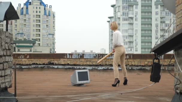 Mooie meisje in hoge hakken slaat de monitor met een vleermuis. Vleermuis, geweld, haat, anarchie, vernietiging, dak van 60 beelden per seconde — Stockvideo