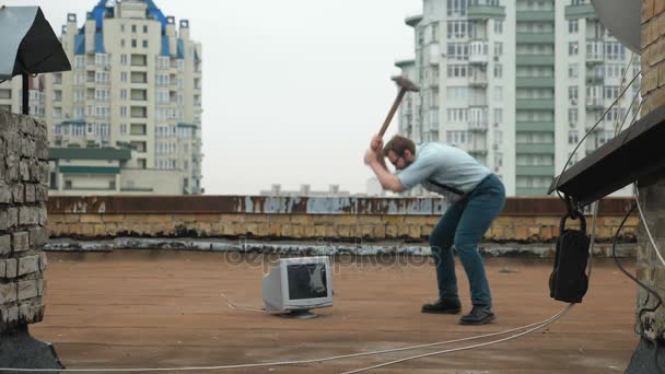 Jonge sterke man slaat de monitor met een moker op het dak. Hamer, geweld, haat, anarchie, vernietiging. 60 fps — Stockvideo