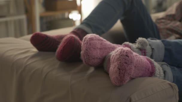 Wans par de pernas encontra-se no sofá em meias de lã, perto de plano, conforto. 60 fps — Vídeo de Stock
