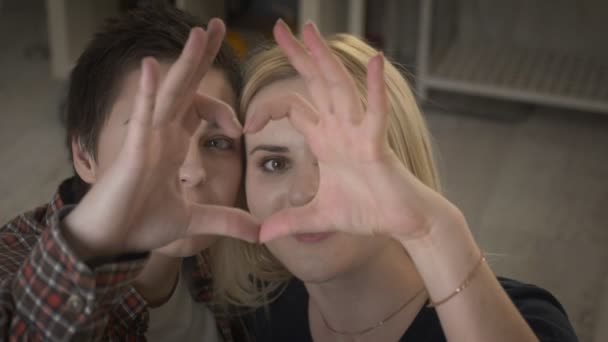 Deux jeunes filles lesbiennes mignonnes câlinent et montrent le signe du cœur, le signe de l'amour 60 fps — Video