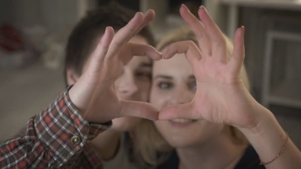 Dos chicas lesbianas lindas jóvenes se acurrucan y muestran el signo del corazón, el signo del amor, la familia 60 fps — Vídeos de Stock