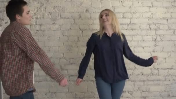 Dvě mladé lesbičky dívky tančí proti bricky bílé stěny pozadí, šťastný pár, rodinný koncept lgbt 60 fps — Stock video