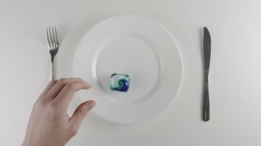 A mans toz pod bir plaka, deterjan pod yıkama el alır. Toz yıkama deterjan ile bir kapsül yemek hazırlama, meydan okuma, internet meme bakla. 60 fps