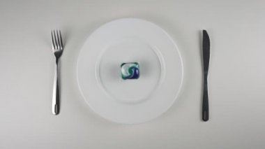 Bir tabakta, deterjan pod pod toz yıkama. Yakınlaştır. Toz yıkama deterjan ile bir kapsül yemek hazırlama, meydan okuma, internet meme bakla. 60 fps