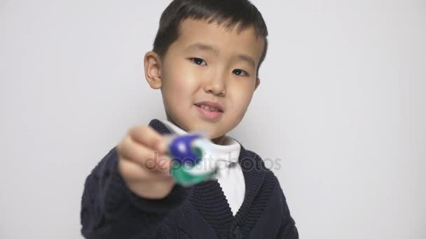 Asiatiska barn innehar tvätt pulver pod i hand, vilket ger en kapsel med rengöringsmedel kameran. Förbereder sig för att äta en kapsel med rengöringsmedel, baljor tvättmedel utmaning, internet meme. fokus dra 60 fps — Stockvideo