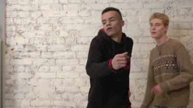 Amerika arkadaşı arka plan üzerinde beyaz tuğla duvar ile dans Afrika adam. Disko, dans, hareket, enerji, gençlik kavramı. 60 fps