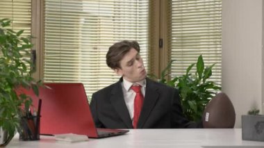 Bir takım elbiseli genç bir adam oturuyor ve Amerikan futbolu için topu atmak çalışıyor. Komedi, mizah, spor kavram. 60 fps