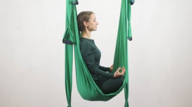 Genç Kafkas kadın kapalı Studio hamakta Anti yerçekimi sinek yoga egzersizleri yapma. Hava aero sinek fitness eğitmeni egzersiz. Lotus poz, derin derin düşünür, uyum ve huzur kavramı 60 fps