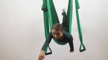 Genç Kafkas kadın kapalı Studio hamakta Anti yerçekimi sinek yoga egzersizleri yapma. Hava aero sinek fitness eğitmeni egzersiz. Süpermen poz, derin derin düşünür, uyum ve huzur kavramı 60 fps