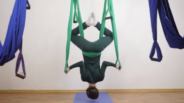 Genç Kafkas kadın kapalı Studio hamakta Anti yerçekimi sinek yoga egzersizleri yapma. Hava aero sinek fitness eğitmeni egzersiz. Omuz streç bilek şal poz, push up. Derin derin düşünür, uyum ve