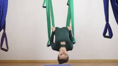 Genç Kafkas kadın kapalı Studio hamakta Anti yerçekimi sinek yoga egzersizleri yapma. Hava aero sinek fitness eğitmeni egzersiz. Layback çapraz pozisyonda derin derin düşünür, uyum ve huzur