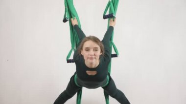 Genç Kafkas kadın kapalı Studio hamakta Anti yerçekimi sinek yoga egzersizleri yapma. Hava aero sinek fitness eğitmeni egzersiz. Yay poz. Derin derin düşünür, uyum ve huzur kavramı, 60 fps yakından