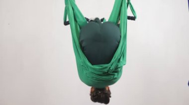 Genç Kafkas kadın kapalı Studio hamakta Anti yerçekimi sinek yoga egzersizleri yapma. Hava aero sinek fitness eğitmeni egzersiz. Takla, rulo, derin derin düşünür, uyum ve huzur kavramı, arka yüzüne