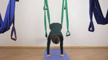 Genç Kafkas kadın kapalı Studio hamakta Anti yerçekimi sinek yoga egzersizleri yapma. Hava aero sinek fitness eğitmeni egzersiz. Hamakta ayaklı tahta. Derin derin düşünür, uyum ve huzur