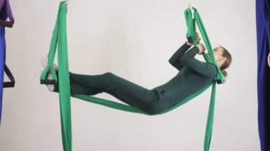 Genç Kafkas kadın kapalı Studio hamakta Anti yerçekimi sinek yoga egzersizleri yapma. Hava aero sinek fitness eğitmeni egzersiz. Layback poz, derin derin düşünür, uyum ve huzur kavramı, yan görünümü 60
