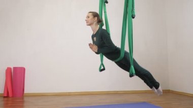 Genç Kafkas kadın kapalı Studio hamakta Anti yerçekimi sinek yoga egzersizleri yapma. Hava aero sinek fitness eğitmeni egzersiz. Hamakta bel ile plank. Derin derin düşünür, uyum ve