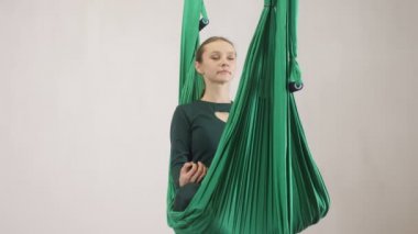 Genç Kafkas kadın kapalı Studio hamakta Anti yerçekimi sinek yoga egzersizleri yapma. Hava aero sinek fitness eğitmeni egzersiz. Lotus poz, derin derin düşünür, uyum ve huzur kavramı, önden görünüm 60