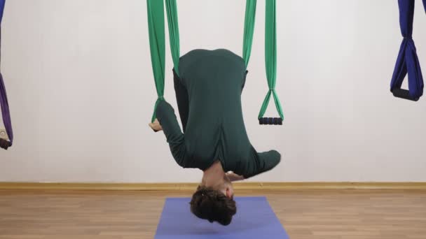 Jonge Kaukasische vrouw maken antigravity vliegen yoga oefeningen in hangmat in studio binnenshuis. Luchtfoto aero vliegen fitness trainer training. Horizontale verzakking. Mediteert, harmonie en rust concept, close-up — Stockvideo