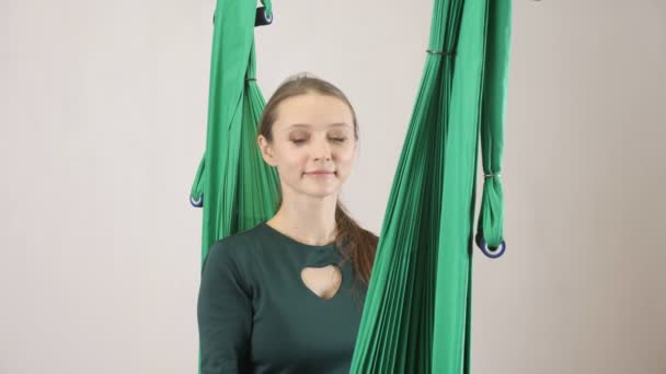 Jeune femme assise sur un hamac et répond à un appel téléphonique, smartphone. Entraînement aérien d'entraîneur de forme physique de mouche d'aéro. Médite, concept d'harmonie et de sérénité, 60 ips — Video