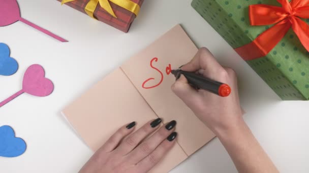De dag van Valentijnskaarten, illustratie, dames hand schrijft in een donker bruin notebook, verkoop 10 procent korting op 60 fps — Stockvideo