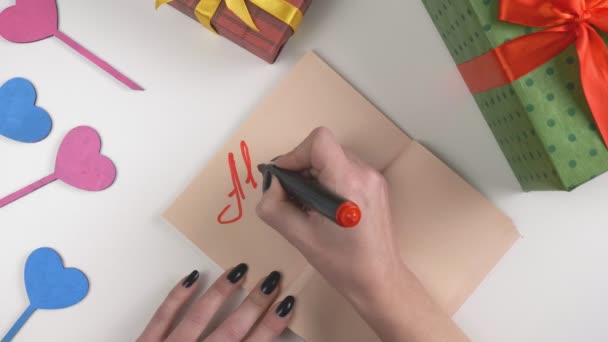 Día de San Valentín, ilustración, la mano de las mujeres escribe en un cuaderno marrón oscuro, Todo lo que necesito es a ti. 60 fps — Vídeo de stock